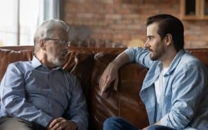 father and son talking at home. Photo credit, Fizkes Dreamstime. For article on A Parkinson’s Disease Caregiver Story Image
