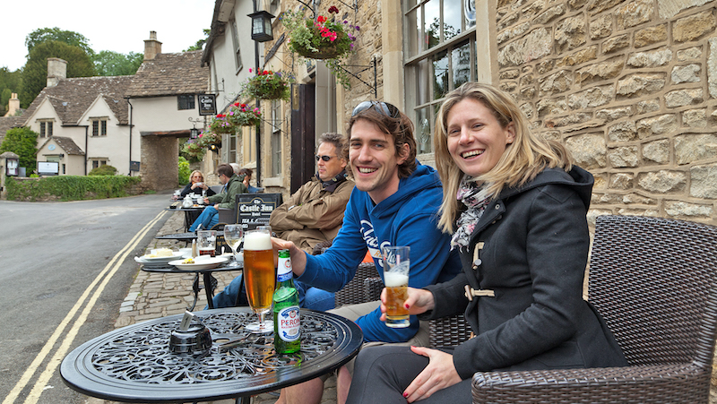 Customers enjoying a beer outside a pub in the Cotswolds, England. Walking Through England’s Quaint Cotswolds Image