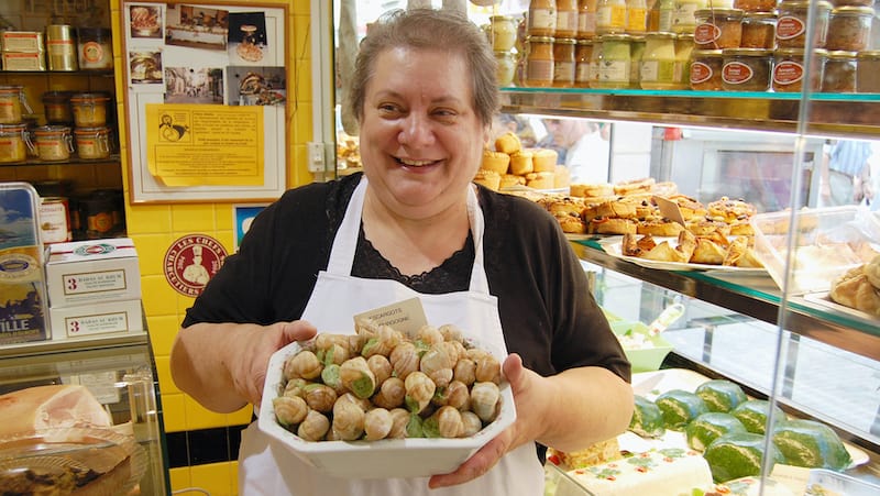 Woman in a French shop holding a platter of escargot. Credit: Rick Steves Europe. For article on the French Passion for Fine Points in Cuisine
