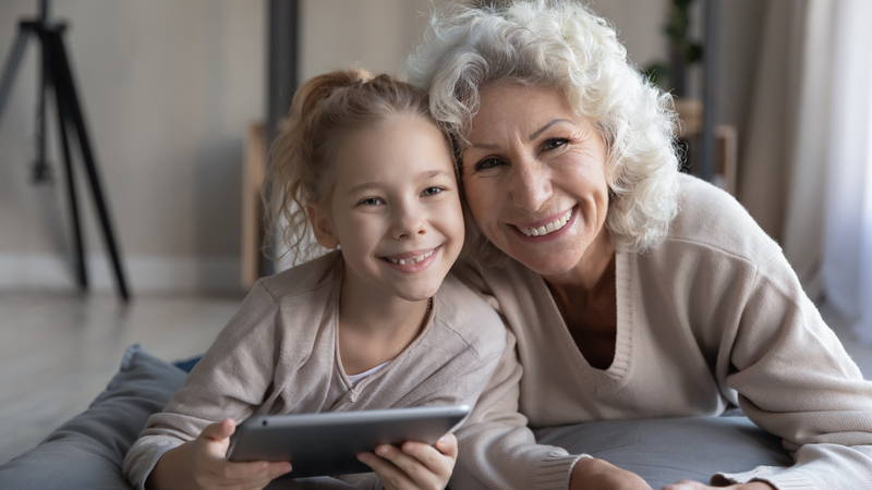 grandma grandaughter on tablet doing puzzle fizkes dreamstime