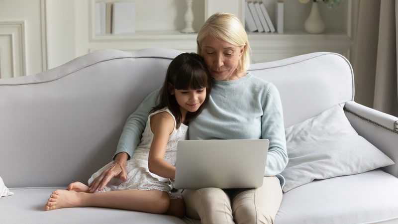 grandmom granddaughter on computer puzzle Credit: fizkes dreamstime Image
