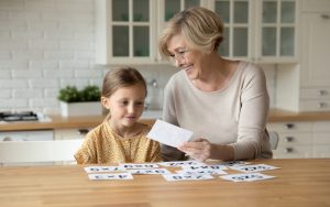 Grandmother and granddaughter playing a card game or puzzle. Photo Fizkes Dreamstime. For article on Jumble puzzles for mental fun Image
