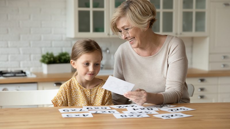 Grandmother and granddaughter playing a card game or puzzle. Photo Fizkes Dreamstime. For article on Jumble puzzles for mental fun Image