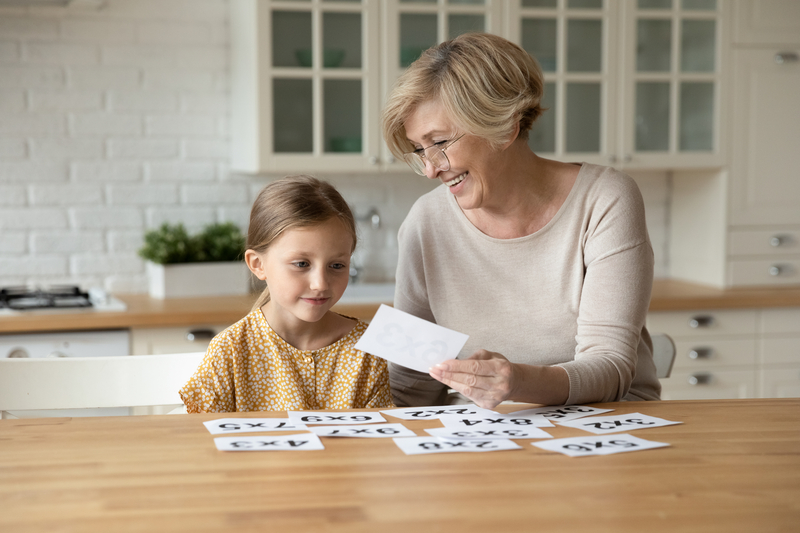 Grandmother and granddaughter playing a card game or puzzle. Photo Fizkes Dreamstime. For article on Jumble puzzles for mental fun