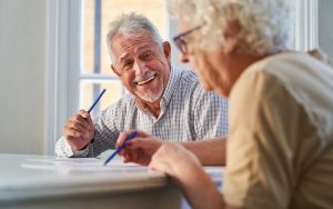 A man and a woman doing puzzles. For Boggle BrainBusters Word Challenge Image