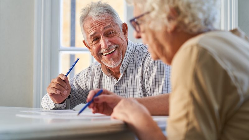 A man and a woman doing puzzles. For Boggle BrainBusters Word Challenge Image