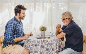 Two men playing chess at a kitchen table Photo Korn Vitthayanukarun Dreamstime. For article on Simple, low-cost, low-tech brain-training activities Image