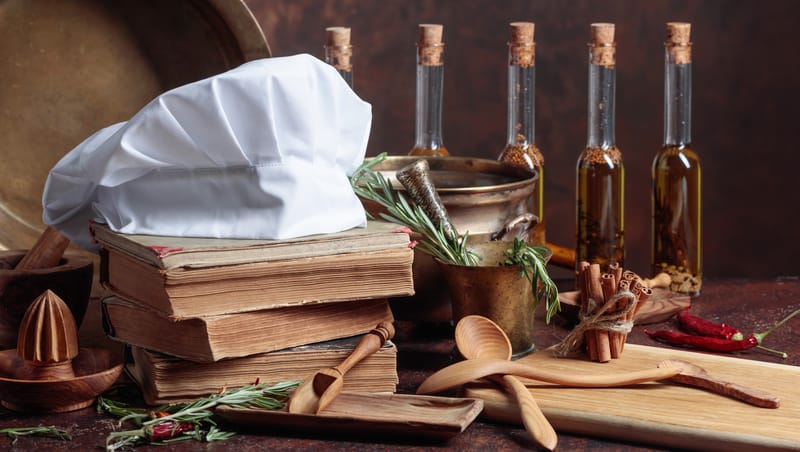 collection of old cookbooks, herbs, spices, and chef's hat. Photo by Igorr Dreamstime. For article on holiday books for cooks