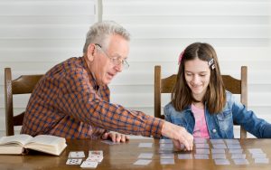 Granddad and granddaughter doing a card game puzzle Image