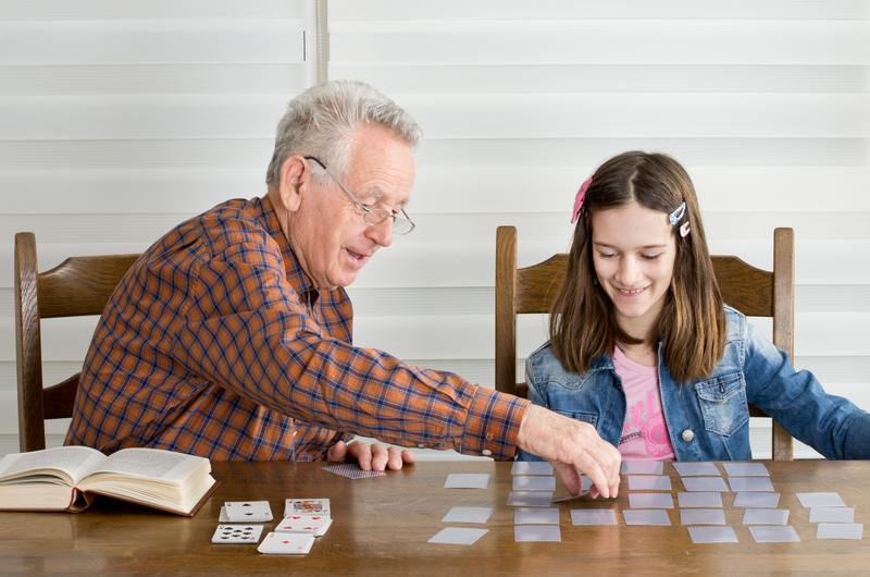 Granddad and granddaughter doing a card game puzzle
