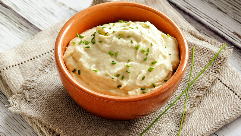 mashed cauliflower in a bowl. For article on healthy vegetarian Thanksgiving dinner tips. Photo from Premium Health