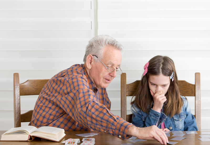 Grandad granddaughter doing a puzzle together Photo by Jevtic Dreamstime