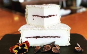 NC cheese from Prodigal Farms is named Piedmont Provencal. It has a layer-cake bloomy rind with olive/basil tapenade in the middle. From Trio Restaurant and Market in North Carolina's Outer Banks / OBX Image