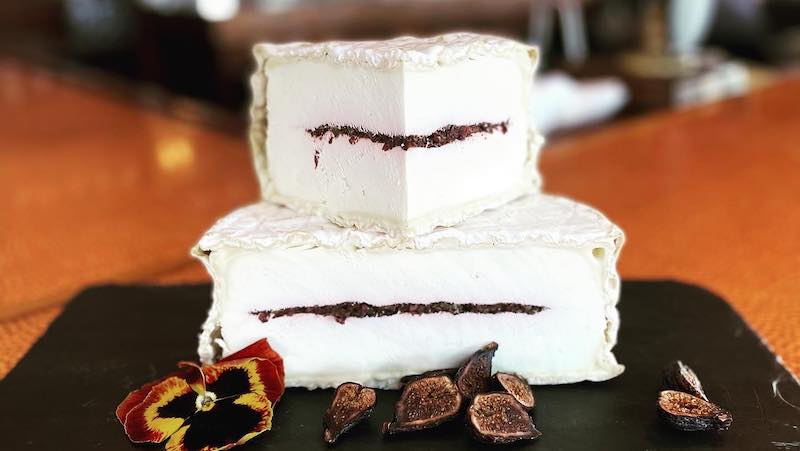 NC cheese from Prodigal Farms is named Piedmont Provencal. It has a layer-cake bloomy rind with olive/basil tapenade in the middle. From Trio Restaurant and Market in North Carolina's Outer Banks / OBX