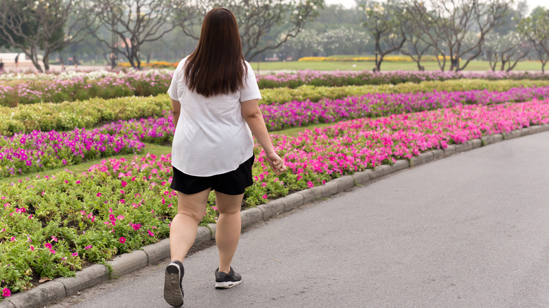 woman in park photo by Bignai Dreamstime. For article, Advice from Amy: ‘My Daughter Is Overweight’ Image