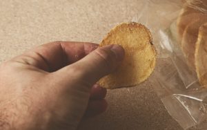 A hand holding a potato chip beside a chip bag. Photo courtesy of Premium Health, Tribune Content Agency. Dietitian Lainey Younkin shares three things you shouldn't do after 5 p.m. if you’re trying to lose weight – three easy lifestyle changes for your health. Image