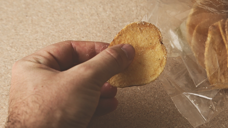 A hand holding a potato chip beside a chip bag. Photo courtesy of Premium Health, Tribune Content Agency. Dietitian Lainey Younkin shares three things you shouldn't do after 5 p.m. if you’re trying to lose weight – three easy lifestyle changes for your health.