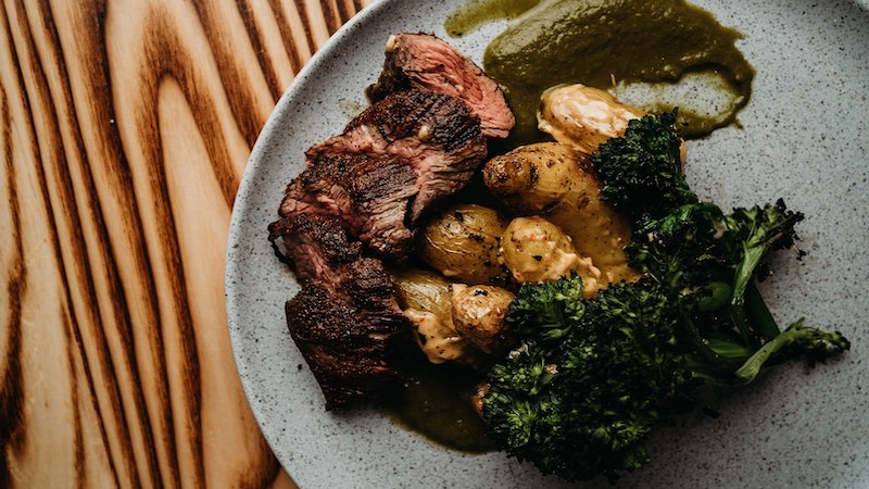 Charred pan seared sirloin with roasted fingerlings in paprika aioli, charred broccolini, and chimichurri at Charred Wood Fired Oven & Craft Bar. Photo from Charred Swift Creek Facebook Image
