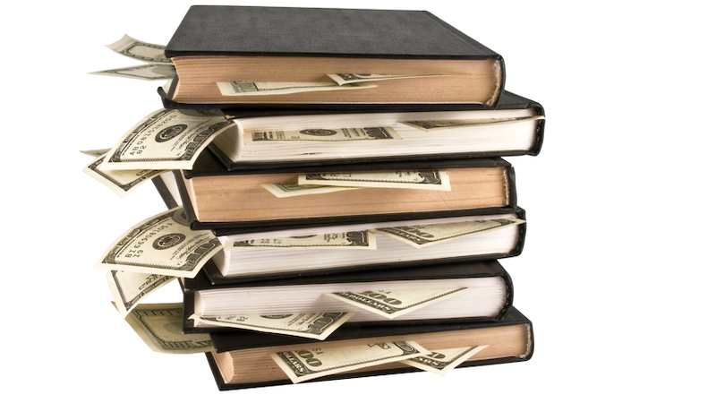 books with $100 bills sticking out Stokato Dreamstime. For article, The Best Financial Books of 2021 Image