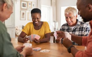 four seniors playing cards Photo by Rido Dreamstime. For article on how to stay social in retirement Image