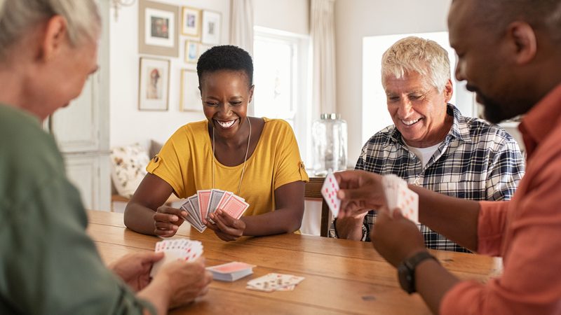 four seniors playing cards Photo by Rido Dreamstime. For article on how to stay social in retirement Image