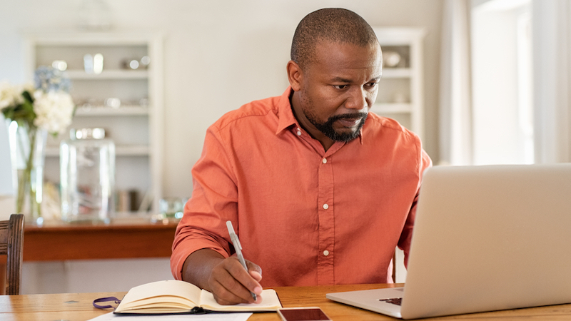 man on laptop maybe doing puzzle photo by Rido Dreamstime