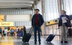 couple at airport in Spain photo by Robwilson39 Dreamstime. For article, As travel ramps up, the experts at Kiplinger’s Personal Finance suggest tips on snagging a lower airfare. Image