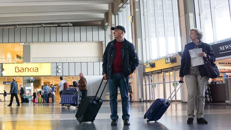 couple at airport in Spain photo by Robwilson39 Dreamstime. For article, As travel ramps up, the experts at Kiplinger’s Personal Finance suggest tips on snagging a lower airfare.