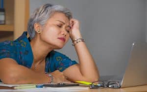 discouraged woman at laptop photo by Marcos Calvo Mesa Dreamstime. For article, Baby boomer and Boomer reader Karen Czuleger Strgacich sings the 