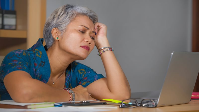 discouraged woman at laptop photo by Marcos Calvo Mesa Dreamstime. For article, Baby boomer and Boomer reader Karen Czuleger Strgacich sings the "unable to retire" blues, at the reasons and at overcoming the regrets.