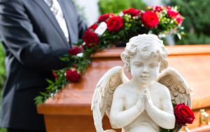 mourning man at coffin during funeral photo by Arne9001 Dreamstime. For article, Years after her divorce, this reader questions the etiquette of attending her ex-in-laws’ funerals. See what Ask Amy has to say. Image