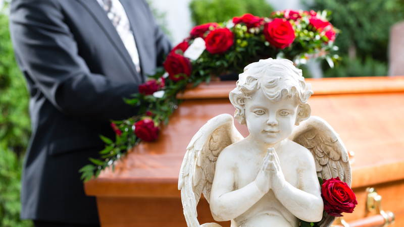 mourning man at coffin during funeral photo by Arne9001 Dreamstime. For article, Years after her divorce, this reader questions the etiquette of attending her ex-in-laws’ funerals. See what Ask Amy has to say.