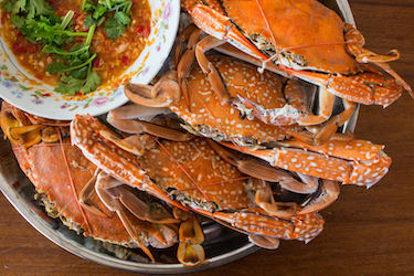 crabs and red sauce, ready for crab picking. Photo 70765545 © Patrapee Tongpliw | Dreamstime.com