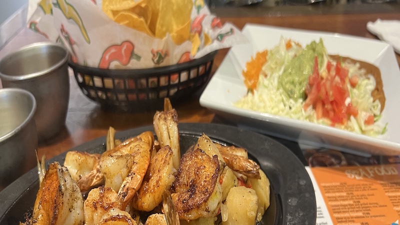 Shrimp, guacamole salad, rice, refried beans, and chips. Potros Mexican Restaurant in Richmond's West End serves delicious sizzling seafood plus traditional and nontraditional Mexican fare. Image