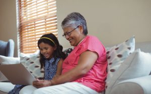 grandmother and granddaughter on a laptop possibly doing online puzzles. photo by Wavebreakmedia Dreamstime. For Jumble fun and games puzzle Image