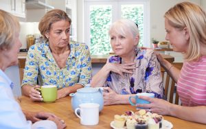 four female friends around a kitchen table consoling one unhappy friend. photo by Ian Allenden Dreamstime. Forged when kids were young, fading since: in the seasons of friendship, is it time to end this one-sided affair? See what “Ask Amy” says.  Image