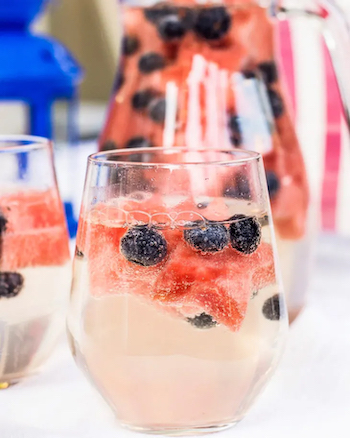 Perky blueberries and star-shaped slices of watermelon bob festively in the Fourth of July wine sparkler.