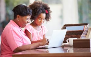 grandmother and granddaughter laptop maybe working on a puzzle - photo by monkey business images, dreamstime Image
