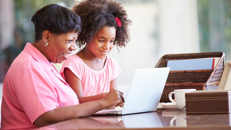 grandmother and granddaughter laptop maybe working on a puzzle - photo by monkey business images, dreamstime Image