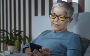 woman wearing blue light blocking photo by Microgen Dreamstime. Blue light-blocking glasses have been shown to spare our eyes from issues with the light from computers. Can they improve our sleep, too?  Image