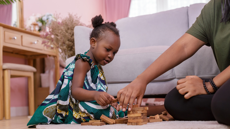 Black child and adult playing puzzle game for Jumble puzzles. Photo by Chayantorn Tongmorn, Dreamstime