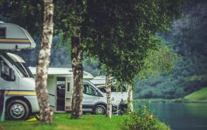 RV camper vans parked beside a lake. Photo by Welcomia, Dreamstime. Image