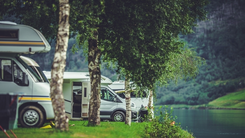 RV camper vans parked beside a lake. Photo by Welcomia, Dreamstime. Image