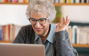 A happy woman at the computer for article on a 60-year-old tempted by an old friend Image