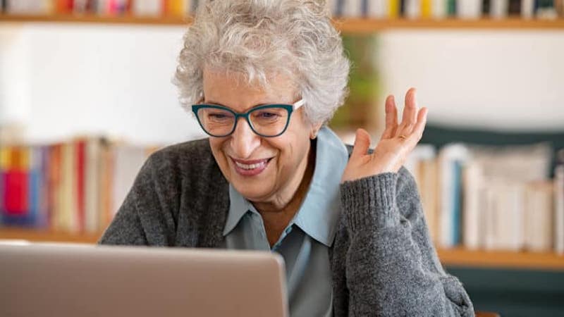 A happy woman at the computer for article on a 60-year-old tempted by an old friend