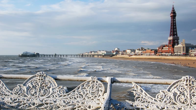 Blackpool is a carnival-esque tipsy-toupee, ears-pierced-while-you-wait place, where I can experience working-class England at play. Showing its beach and tower.