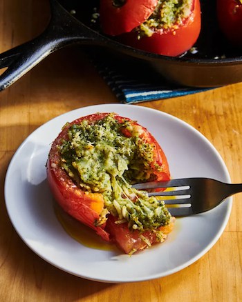 Ripe tomatoes filled with gooey cheese and basil pesto, grilled, and finished with toasted pine nuts. Ripe and juicy grilled stuffed tomatoes, a summertime rewards, are stuffed with cheese, rice, and pesto, topped with toasted pine nuts.