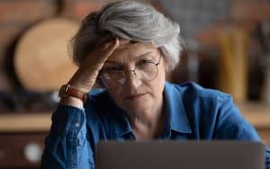 Concerned woman looking at laptop. Photo by Fizkes, Dreamstime. Longtime friends ghosted her and cut off contact, but now she is concerned for their health. Should she reach out? See what Ask Amy says. Image