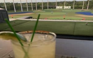 A cocktail in the foreground from a third-level bay at Drive Shack in Short Pump, near Richmond, Virginia Image