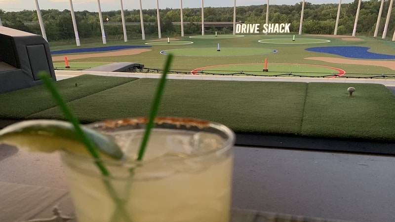 A cocktail in the foreground from a third-level bay at Drive Shack in Short Pump, near Richmond, Virginia